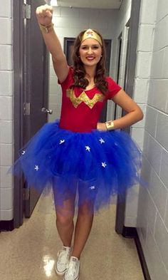 a woman in a red shirt and blue tutu skirt is standing in a hallway