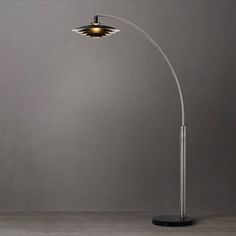 a lamp that is on top of a wooden table next to a gray wall and floor