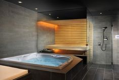 a bathroom with a large jacuzzi tub and television on the wall next to it