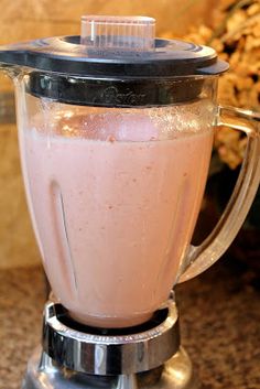 a blender filled with pink liquid sitting on top of a counter