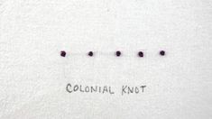 the words colonial knot written on a white piece of cloth with small black dots in it