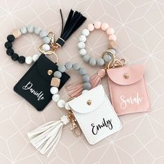 four personalized key chains with tassels and charms on top of each one