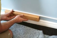 a man is working on the base of a window sill with wood and glue