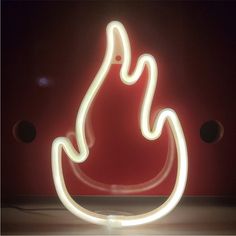 a neon sign that is lit up in front of a red wall with circles around it