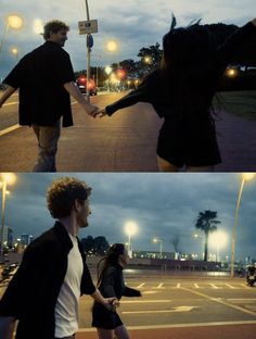 two people holding hands walking down the street at night and in the dark with lights on