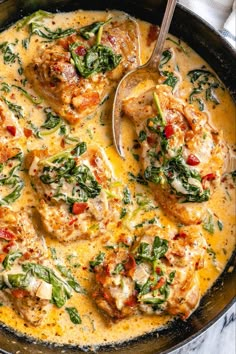 a skillet filled with chicken and spinach covered in gravy on top of a marble counter