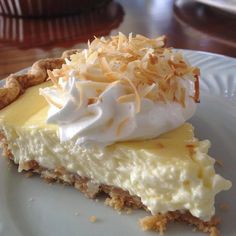 a piece of pie on a plate with whipped cream and toasted crumbs