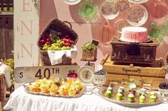 a table topped with lots of desserts next to a sign that says 40th