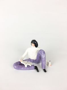 a figurine is sitting on the ground with a paintbrush in his hand