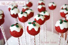 strawberries with white icing and green leaves on top are arranged on sticks in the shape of snowmen