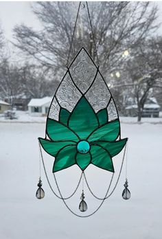 a stained glass wind chime hanging in the snow