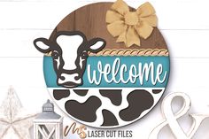 a wooden sign that says welcome with a cow on the front and side of it