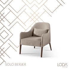 a beige chair sitting in front of a white wall with gold geometric lines on it