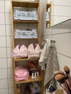 there are many different items on the shelves in this bathroom, including makeup brushes and slippers