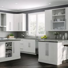 a modern kitchen with white cabinets and stainless steel appliances, along with dark wood flooring