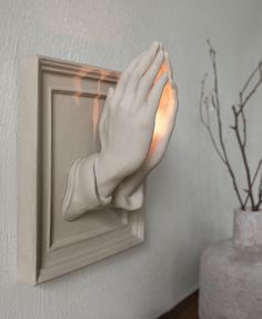 a hand that is on the side of a wall holding something in it's palm