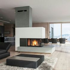 a living room filled with furniture and a fire place next to a dining table on top of a hard wood floor