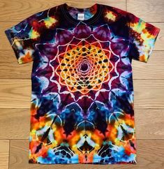 a colorful t - shirt with an image of a flower in the center on it