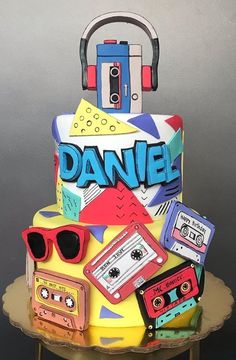 a multi - layered cake decorated with cassettes, headphones and tape recorders