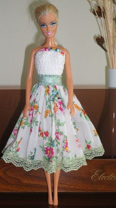 the doll is wearing a dress with flowers on it