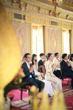 a group of people sitting next to each other at a formal event in a room