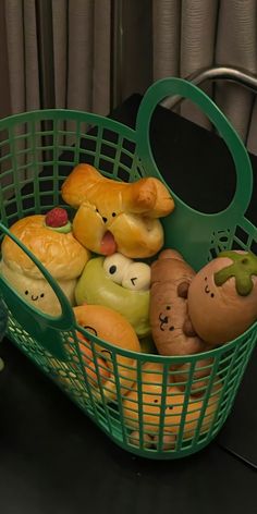 a green basket filled with lots of different types of pastries on top of a table