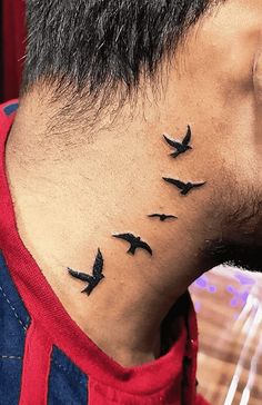 a man's neck with birds on it