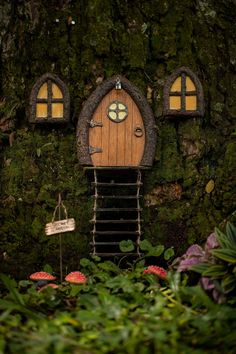 a small house made out of moss with two windows and a door in the middle