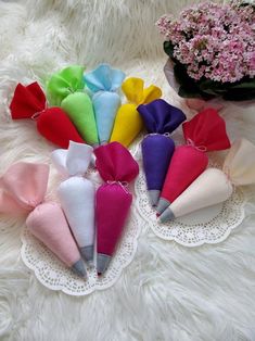 several different colored bows are sitting on a white doily next to pink and purple flowers