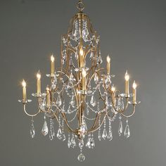 a gold chandelier with crystal drops hanging from it's center and four lights on each side