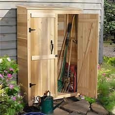 a wooden storage shed with gardening tools in it