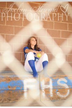 a woman sitting on top of a wooden bench holding a baseball ball and wearing blue socks