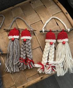 three crocheted tassels with red and white trim sitting on top of a wooden table