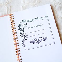 a note book with a floral design on the front and back cover that says this journal belongs to