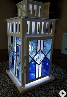 a house made out of stained glass sitting on top of a carpeted floor in front of a wall