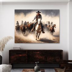 a painting of cowboys riding horses in the desert