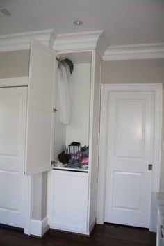 an open closet with clothes hanging on the door