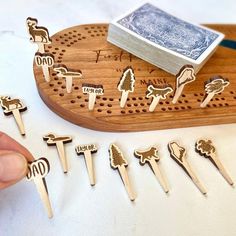 a person is holding a wooden peg board with many different types of pins on it