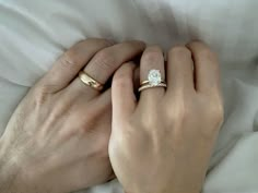 two hands holding each other while wearing wedding rings