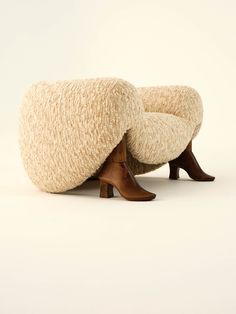 a pair of foot stools made out of sheep wool and wooden legs, sitting on a white background