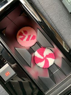 two pink and white cupcakes sitting on top of a toaster oven door