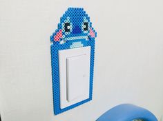 a blue light switch cover sitting on top of a white wall next to a blue chair