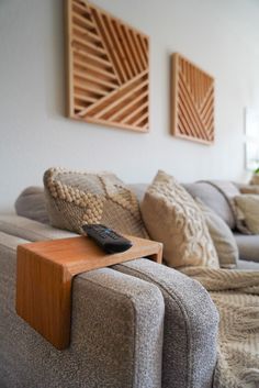 a remote control sitting on top of a wooden table in front of a gray couch