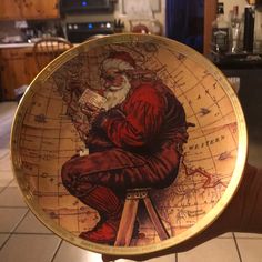 a person holding up a plate with a santa clause on it in a kitchen area