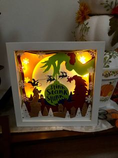 a lit up shadow box with an image of dinosaurs on it