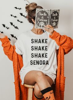 Spooky Season is here! Our Shake Shake Shake Señora t-shirt is the perfect addition to your fall wardrobe. With a fun nod to our favorite halloween movie, Beetlejuice. Everyone will be singing along to this cute graphic tee. Grab your pumpkin spice latte and hit the pumpkin patch or haunted house in our fun Halloween t-shirts Shake Shake Shake Señora Short-Sleeve Unisex T-Shirt, graphic t-shirt, Halloween t-shirt, Halloween shirt, BeetleJuice shirt, fall shirt This t-shirt is everything you've d Disney Shirts For Halloween, Oogie Boogie Bash Outfit, Disney Halloween Shirts, Shake Shake, Halloween Festivities, Disney Bounding, Halloween Movie, Halloween Shirts, Halloween Movies