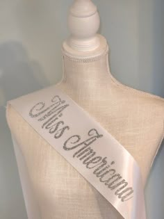 a mannequin with a white sash on it