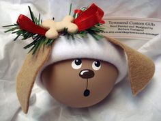 an egg with a dog's head wearing a santa claus hat and red bow