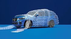 a car made out of plastic bottles on a blue surface with white tape around it