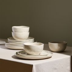 a table topped with white plates and bowls